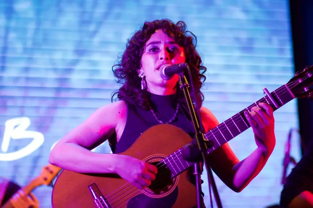 Karol Barboza cantando e tocando violão durante Cantería Live Sessions em London Room, San José, Costa Rica / enotar.io